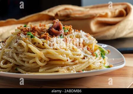 Italienische Spaghetti pasta mollicata mit semmelbröseln Parmesan in einem Sardellen Weißweinsauce Stockfoto