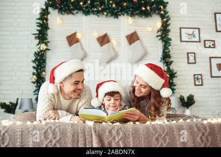 Freundliche Familie lesen Buch in der Weihnachtszeit Stockfoto