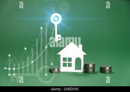 Papier Haus Modell, Diagramm und Key Image, Geld auf grünem Hintergrund. Einsparungen Geld für Haus kaufen und Darlehen an Unternehmen von Investitionen für Immobilien conce Stockfoto