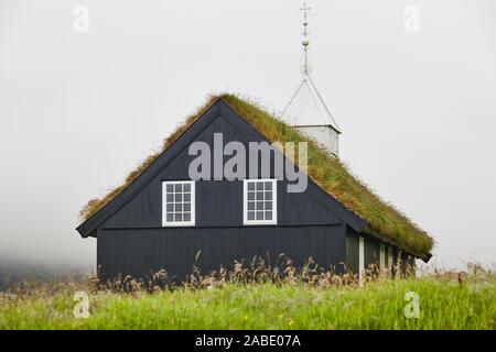 Die traditionellen färöischen Kirche mit Grasdach auf einem nebligen Tag. Stockfoto