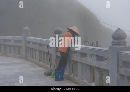 SaPa, Vietnam - 20. August 2017: Sauberer, Arbeiter in der traditionellen Vietnamesischen hat ihr Handy surfen Stockfoto