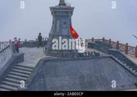 SaPa, Vietnam - 20. August 2017: asiatische Touristen mit vietnamesischen Flagge auf Fansipan Gipfel Stockfoto