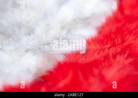 Pelz Textur Hintergrund. Rote und weiße flauschige Fell diagonal mit flachen selektiven Fokus in der Mitte. Langer Flor. Kopieren Sie Platz. Stockfoto