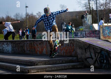 Eine süße kleine Jungen mit ADHS, Autismus, Asperger Syndrom verbrennt Energie auf dem Skateboard Park, üben Tricks wie der Ollie und springen Schritte Stockfoto