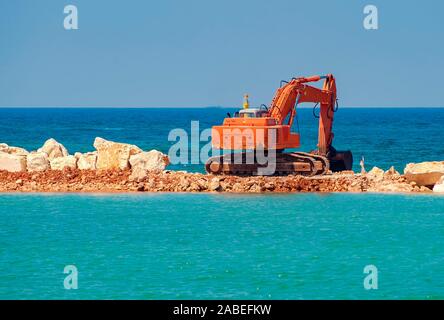 Baumaschinen auf dem Ufer, den Bau von Wellenbrechern, Küstenschutz Maßnahmen Stockfoto