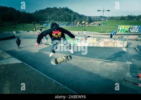 Skateboarder Ollie aus hohen Schritte auf das Konkrete unten, gefährliches Abenteuer, Extremsport, professionelle Skater, Skateboard Stockfoto