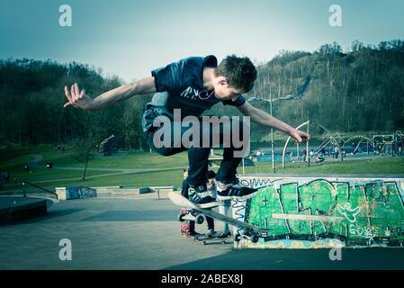 Skateboarder Ollie aus hohen Schritte auf das Konkrete unten, gefährliches Abenteuer, Extremsport, professionelle Skater, Skateboard Stockfoto