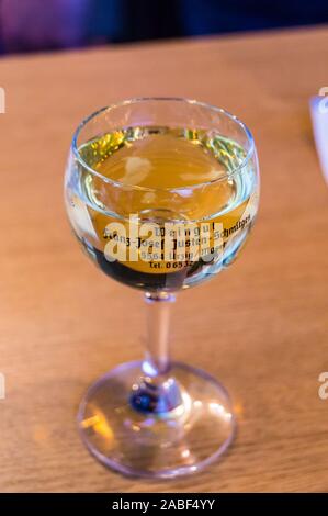 Ein Glas Riesling vom Weingut Justen-Schmitges, Ürzig, Mosel, Rheinland-Pfalz, Deutschland auf einem Stand auf dem Weinfest Stockfoto