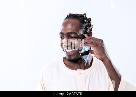 Afrikanischer Mann mit Smartphone und tragen traditioinal Sudan Kleidung auf weißem Hintergrund Stockfoto