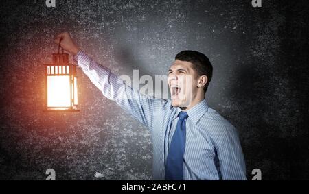 Schreien Geschäftsmann Holding leuchtende Laterne Stockfoto