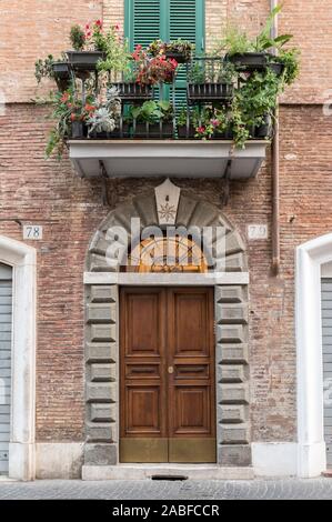 Alte Holztür, in eine verzierte Steinmauer gesetzt Stockfoto