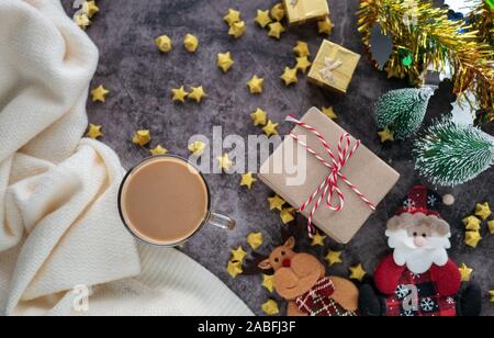 Heißer Kaffee im Winter mit Weihnachten Hintergrund Dekorationen und Geschenkboxen auf Tisch Stockfoto