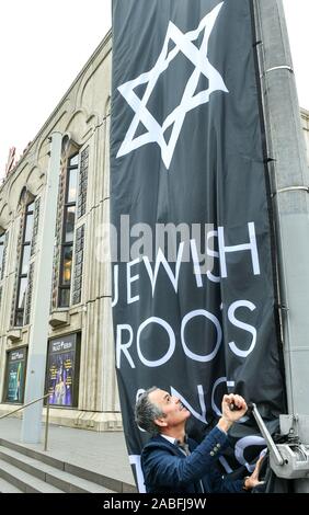 Berlin, Deutschland. 27 Nov, 2019. Direktor Berndt Schmidt Hebezeuge eine Flagge mit dem Davidstern und die Inschrift "Jüdischen Wurzeln seit 1919" zu Ehren seiner jüdischen Gründerväter M.Reinhardt und Direktor E. Charell in der Vorderseite des Friedrichstadt-palastes anlässlich des 100 jährigen Bühnenjubiläum. Foto: Jens Kalaene/dpa-Zentralbild/dpa/Alamy leben Nachrichten Stockfoto