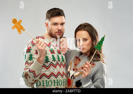 Paar mit Weihnachtsfeier Requisiten in hässlichen Pullover Stockfoto