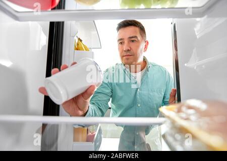 Mann das Essen aus dem Kühlschrank in der Küche Stockfoto