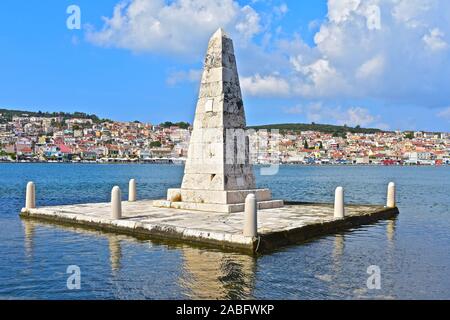 Die kolona Obelisk aus dem Jahre 1813, von De Bosset Brücke mit der Stadt Argostoli Waterfront im Hintergrund gesehen. Stockfoto