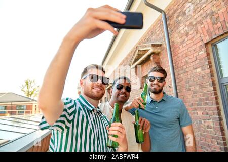Männer trinken Bier und unter Berücksichtigung von selfie Smartphone Stockfoto