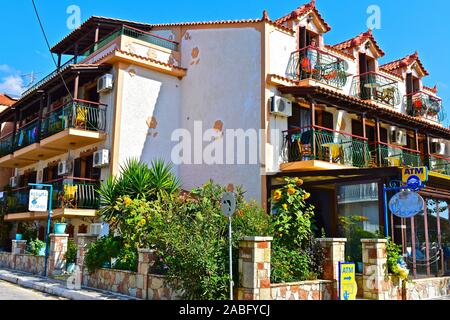 Hübsches Gebäude an der Hauptstraße von Katelios belegt als Medrese Fische Tavern Restaurant mit Ferienwohnungen. Dame auf einem Balkon. Stockfoto