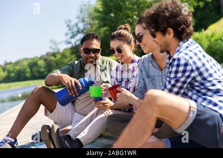 Gerne Freunde trinken Kaffee aus der Thermoskanne im Sommer Stockfoto