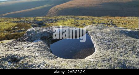 Kleine Pfütze im Stein im Nationalpark Dartmoor, Devon Stockfoto