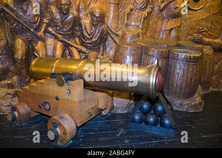 Gun Anzeige eines frühen Canon und kanonenkugeln vor einem Tableau der Schlacht an der Explosion Museum der Naval Feuerkraft; ehemaliger Rüstung Depot der Royal Navy von priddy ist hart, in Gosport. Großbritannien (105) Stockfoto