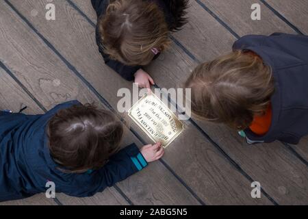 Besucher/Touristen untersuchen die Metall Messingschild auf der Website von HMS Victory an der Stelle, wo Admiral Lord Nelson fiel nach geschossen wird von einem französischen Musketier. Portsmouth. Großbritannien (105) Stockfoto