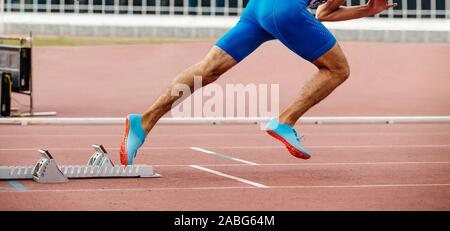 Männliche Läufer starten Sprint mit startblöcken Stockfoto
