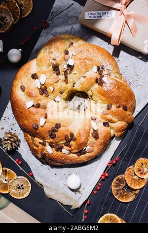 Frisch gebackene chrismtas roll Kranz auf einem hölzernen Hintergrund mit verschiedenen Weihnachten Dekoration Stockfoto