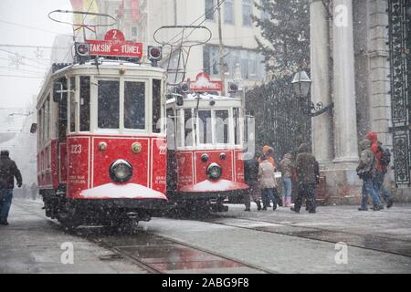 Istanbul, Taksim, Türkei - Januar 8, 2013: eine nostalgische Straßenbahnen vorbei vor dem Galatasaray High School an der Istiklal Straße, wenn schneit. Stockfoto