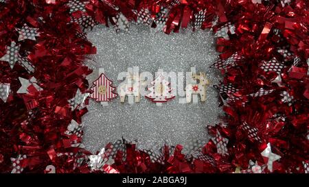 Weihnachtsdekoration. Rot und Silber Twisted Lametta Girlande als Frame. Silber Glitzer Hintergrund. Stockfoto