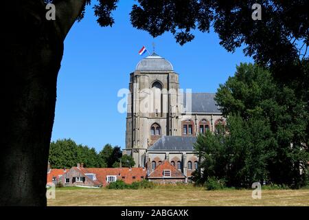 Die niederländische Flagge stolz über die spätgotischen Kirche Unserer Lieben Frau - Grote Kerk (1450-1521) in Veere, Niederlande fliegen Stockfoto