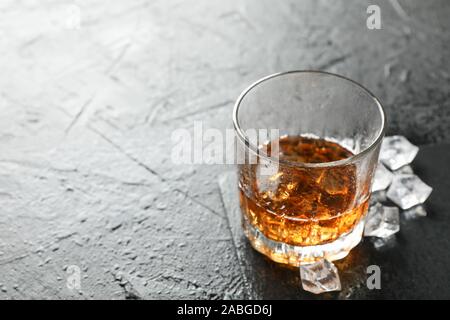 Glas Whiskey und Eiswürfel auf schwarzem Hintergrund, kopieren Raum Stockfoto