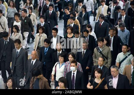 Massen von Pendlern zu Fuß während des morgendlichen Berufsverkehrs im Zentrum von Tokyo Japan zu arbeiten Stockfoto