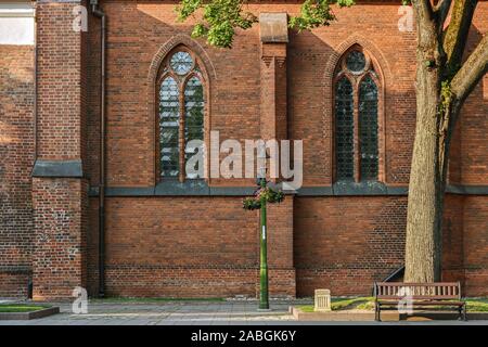 Zwei gewölbte Fenster mit Glasmalerei auf der Wand der Kathedrale der Heiligen Peter und Paul, in der Altstadt von Kaunas. Aus den Fenstern der w Stockfoto