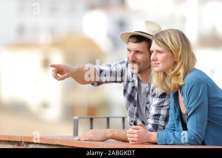 Paar Touristen Sightseeing auf Horizont stehen draußen in einen Balkon in einer ländlichen Stadt an einem sonnigen Tag Stockfoto