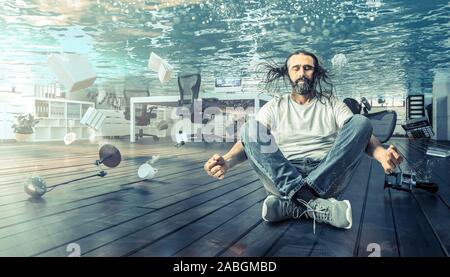 Mann sitzt unter Wasser, das in einem Yoga Position entspannt. Büro komplett überflutet. Konzept der Probleme und der Ruhe. Stockfoto