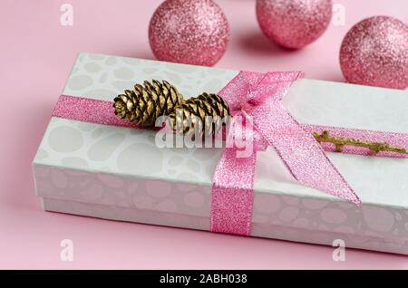 Rosa Weihnachten Hintergrund. Geschenkbox mit Schleife und Flitter, aus der Nähe. Stockfoto