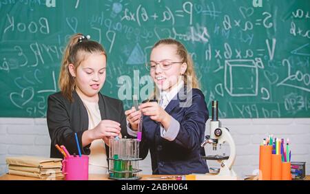 Sicherheitsmaßnahmen für die sichere chemische Reaktion. Genius Kinder arbeiten an eigenen chemischen Theorie. Grundkenntnisse der Chemie. Schüler nette Mädchen Röhrchen mit Flüssigkeiten verwenden. Chemisches experiment Konzept. Stockfoto
