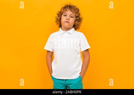 Europäische rothaarige Junge in einem weißen T-Shirt mit gelbem Hintergrund Stockfoto