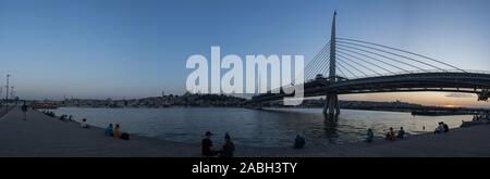 Istanbul: Sonnenuntergang mit Panoramablick auf die Skyline und das Atatürk Brücke, Autobahn Brücke über das Goldene Horn, aus dem öffentlichen Park entlang dem Wasser gesehen Stockfoto