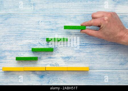 Wachstum und Erfolg Konzept. Männliche hand Organisation Bausteine als Treppenstufen. Stockfoto