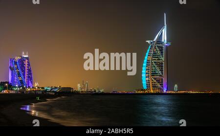 DUBAI, VEREINIGTE ARABISCHE EMIRATE - Feb 11, 2019: Das Burj Al Arab oder Turm der Araber, ein Luxushotel in Dubai mit Marina Towers im Hintergrund, United ein Stockfoto