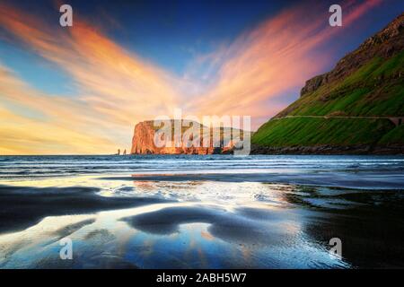 Unglaubliche Sonnenuntergang bei Ebbe am Atlantik Küste in der Nähe von Dorf Tjornuvik. Berühmten Felsformationen Risin und Kellingin Eidiskollur für den Hintergrund. Färöer, Dänemark. Landschaftsfotografie Stockfoto