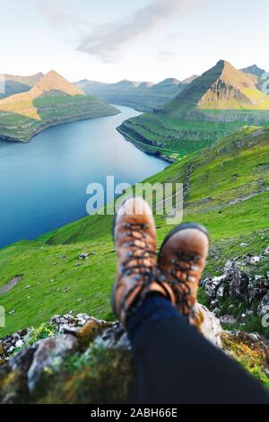 Stiefel von einsamen Tourist über majestätische Fjorde von Funningur, Eysturoy Island, Färöer Inseln. Landschaftsfotografie Stockfoto