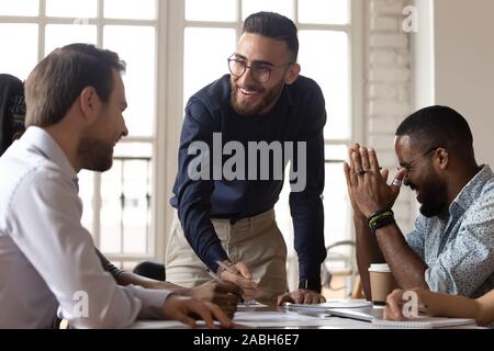 Glückliche junge Manager Spaß mit gemischten Rennen Kollegen. Stockfoto