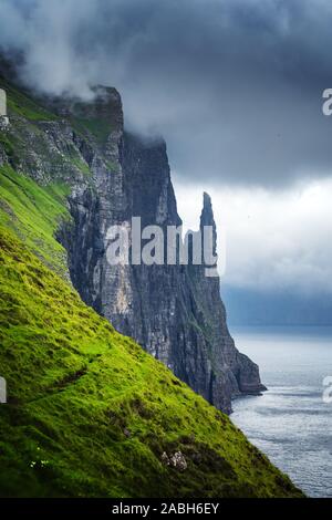 Wunderschöne färöische Landschaft mit berühmten Hexen Finger Klippen und dramatische Wolkenhimmel aus Trollkonufingur Aussichtspunkt. Vagar Island, Färöer, Dänemark. Stockfoto