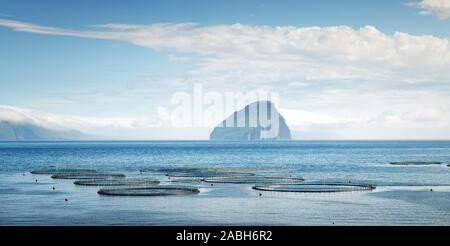 Panoramaartigem Blick auf Fisch Farm in der Nähe von Sandavagur Dorf auf Vagar Insel Koltur Insel im Hintergrund. Färöer, Dänemark. Stockfoto