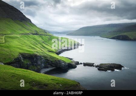 Dramatischen Blick auf grünen Hügeln von Vagar Insel und Sorvagur Stadt auf Hintergrund. Färöer, Dänemark. Landschaftsfotografie Stockfoto