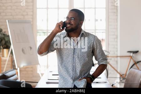Erfolgreiche tausendjährigen gemischten Rennen Geschäftsmann mit Mobiltelefon anrufen. Stockfoto