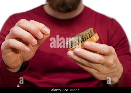 Mann mit Bart zieht Haare, Bart Bürste, close-up der Reinigung Haar isoliert auf weißem Stockfoto